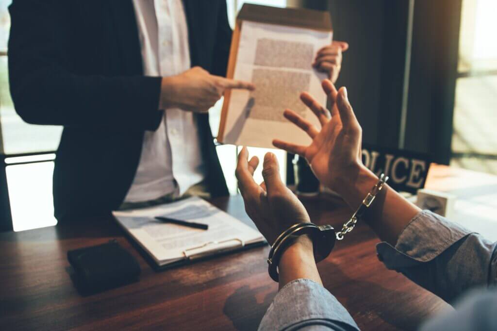 Person in handcuffs consulting with attorney, falsely accused in Georgia